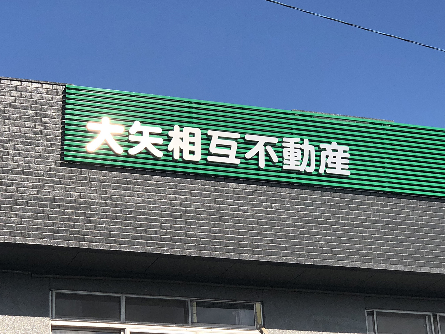 ブランドカラーに映えるステンレスヘアラインの文字看板 愛知県稲沢市